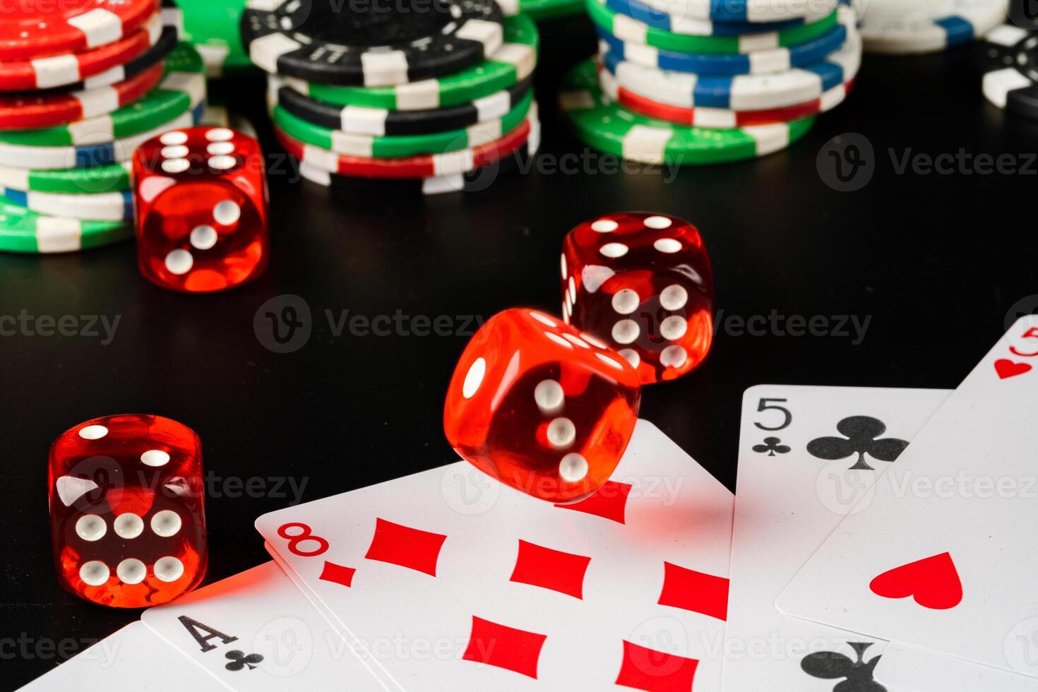 Dice and chips on black table close up photo