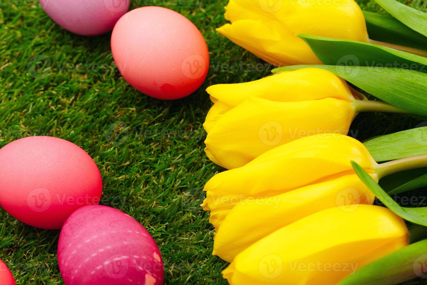Colored Easter eggs on grass decorated with flowers photo