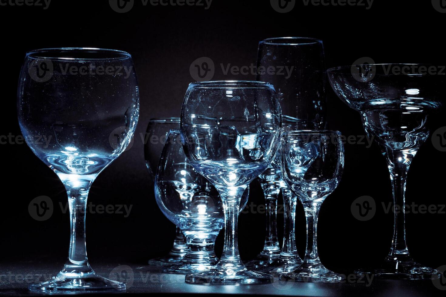 Empty glasses for drinks on dark background photo