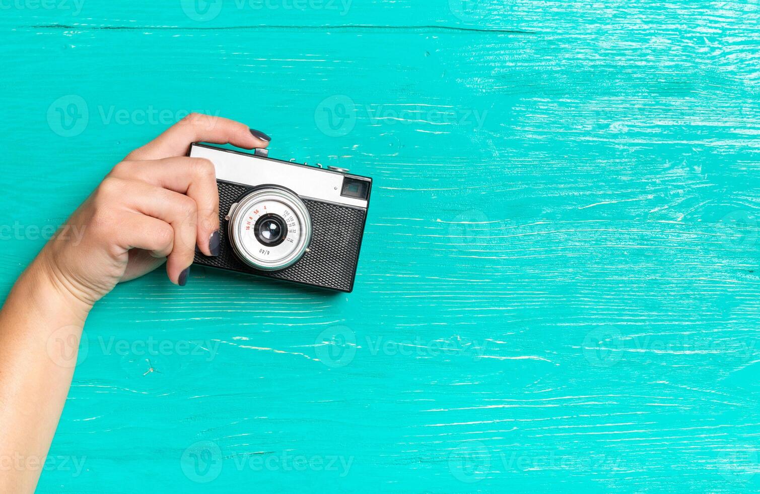 woman's hands holding a retro camera photo