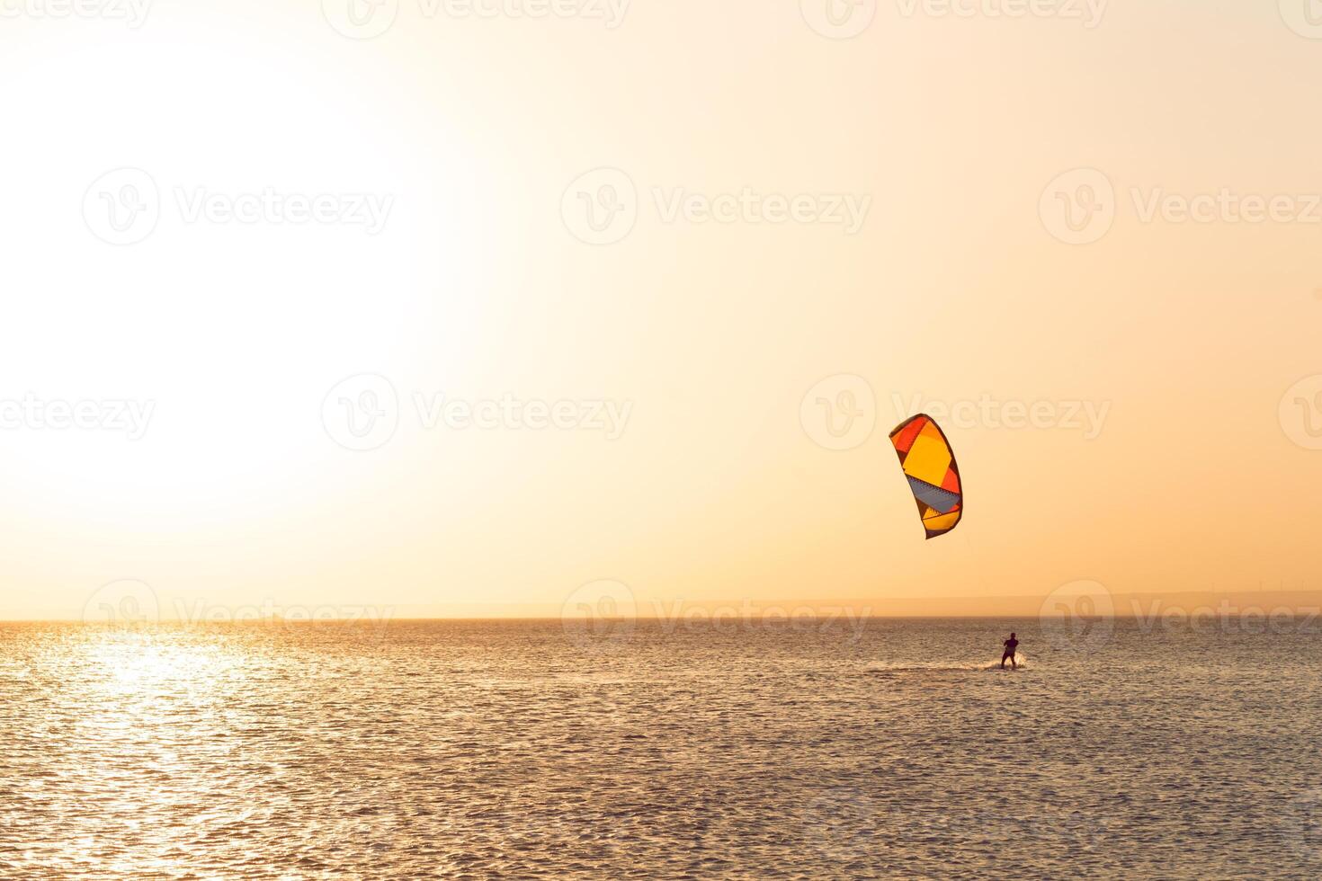 Kitesurfing at sunset at sea photo