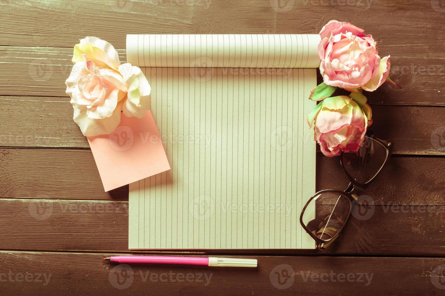 flowers and a notebook on wooden background photo