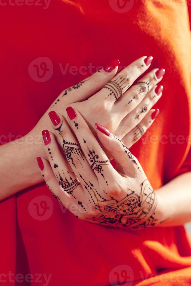Red manicured hands with Mehndi photo