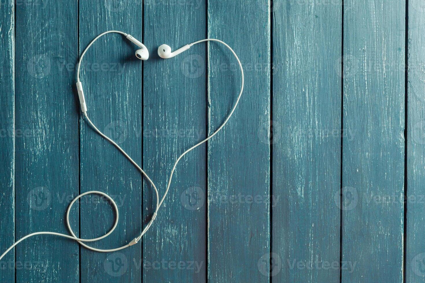 Modern portable audio earphones on wood board photo