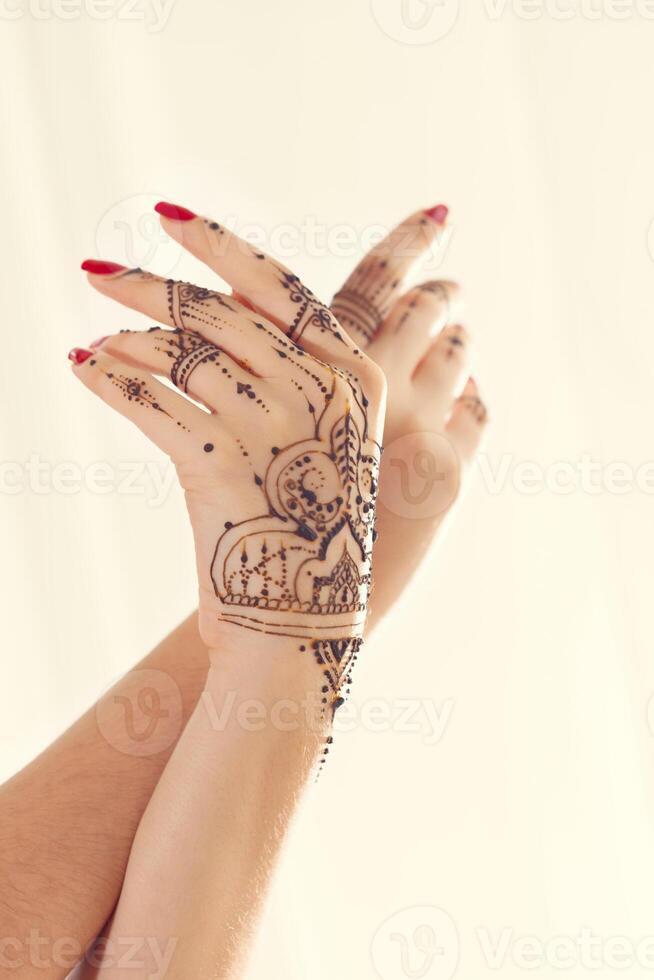 Red manicured hands with Mehndi photo