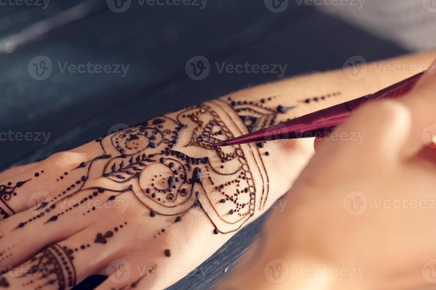 Process of applying mehndi on female hands photo