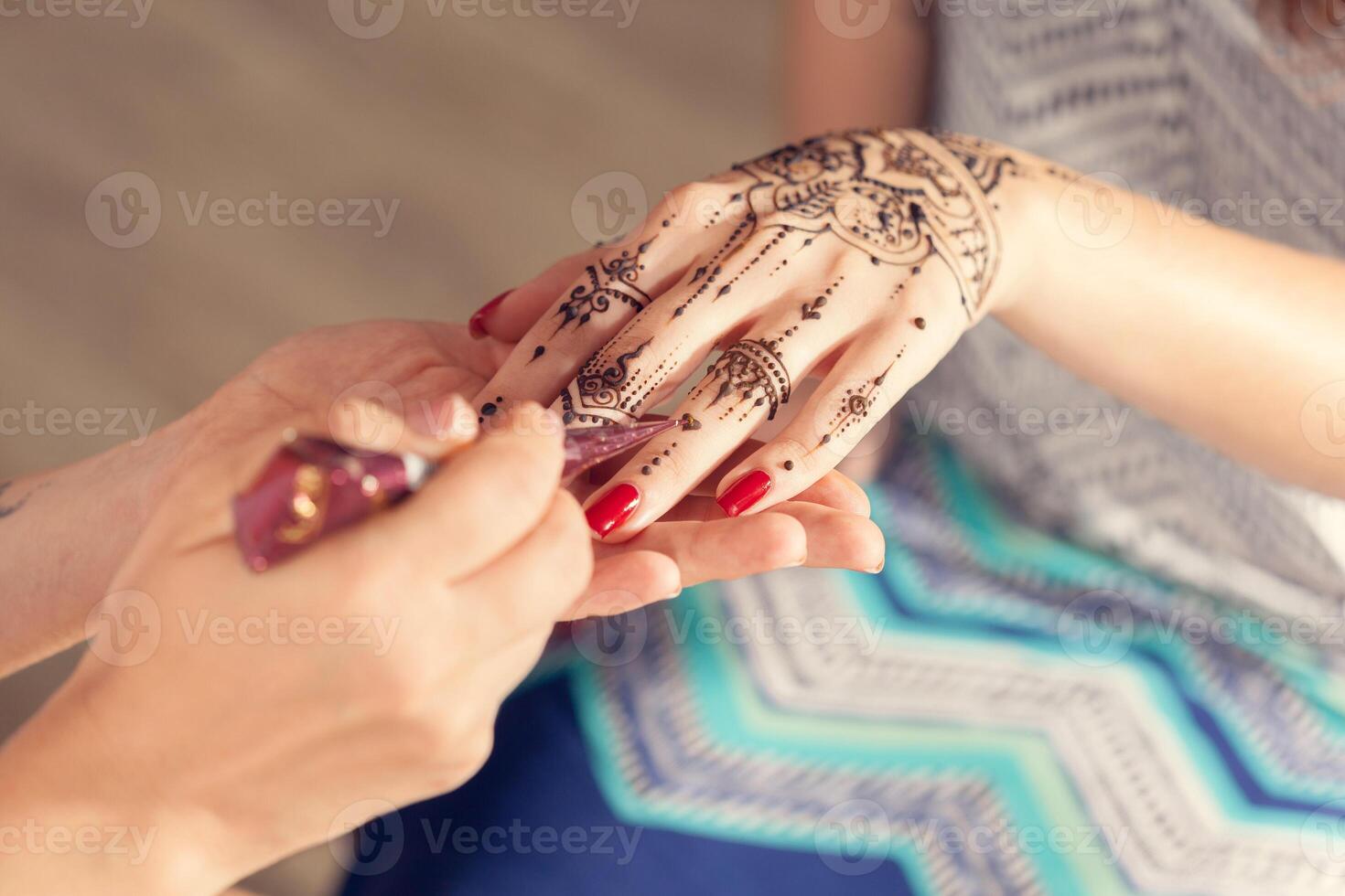 Process of applying mehndi on female hands photo