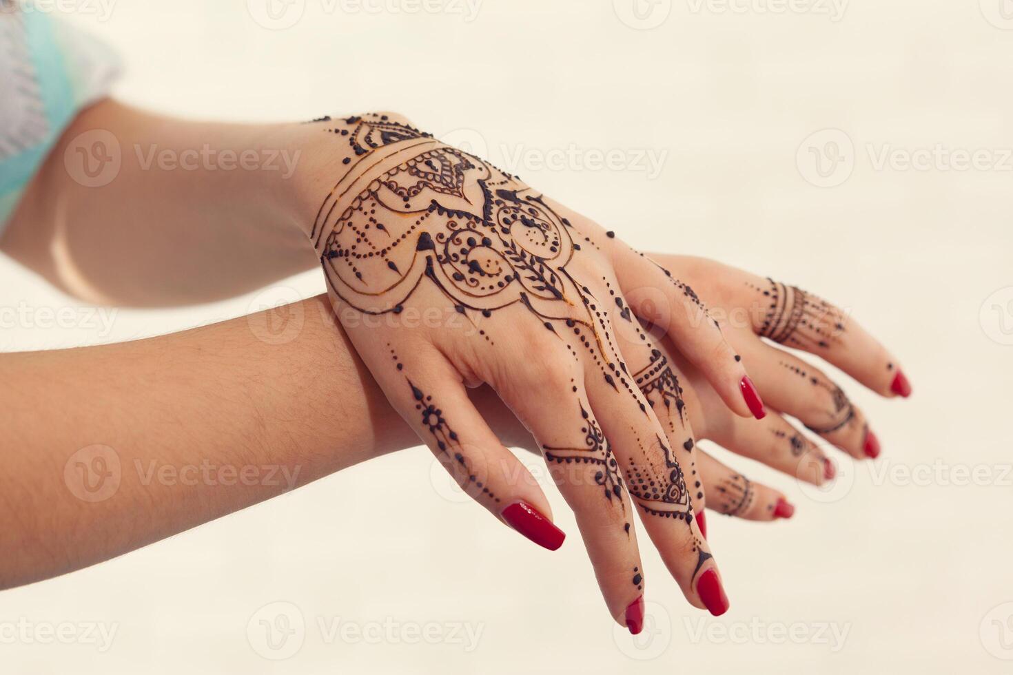 Red manicured hands with Mehndi photo