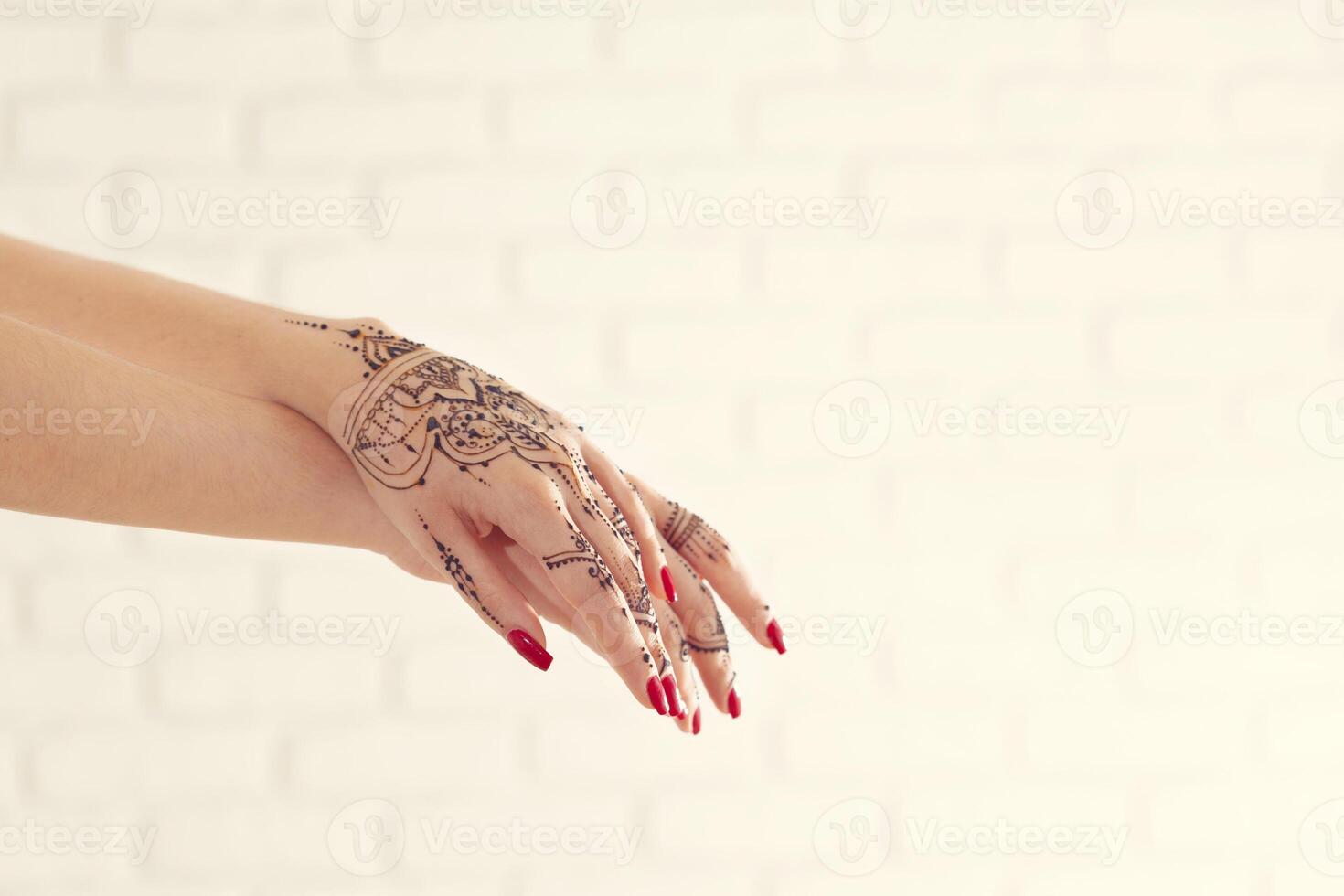 Red manicured hands with Mehndi photo