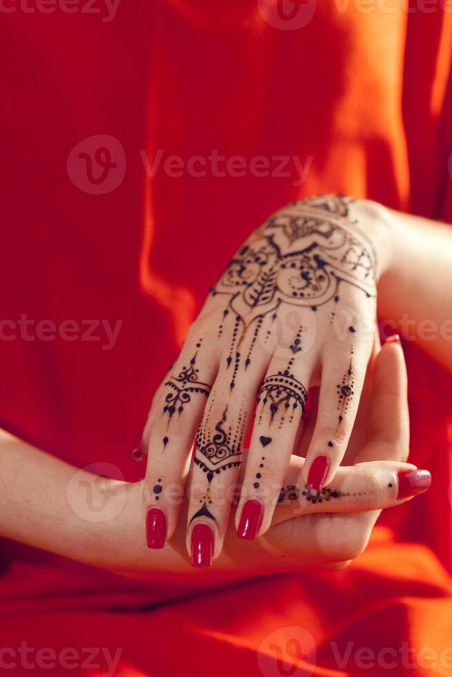 Red manicured hands with Mehndi photo
