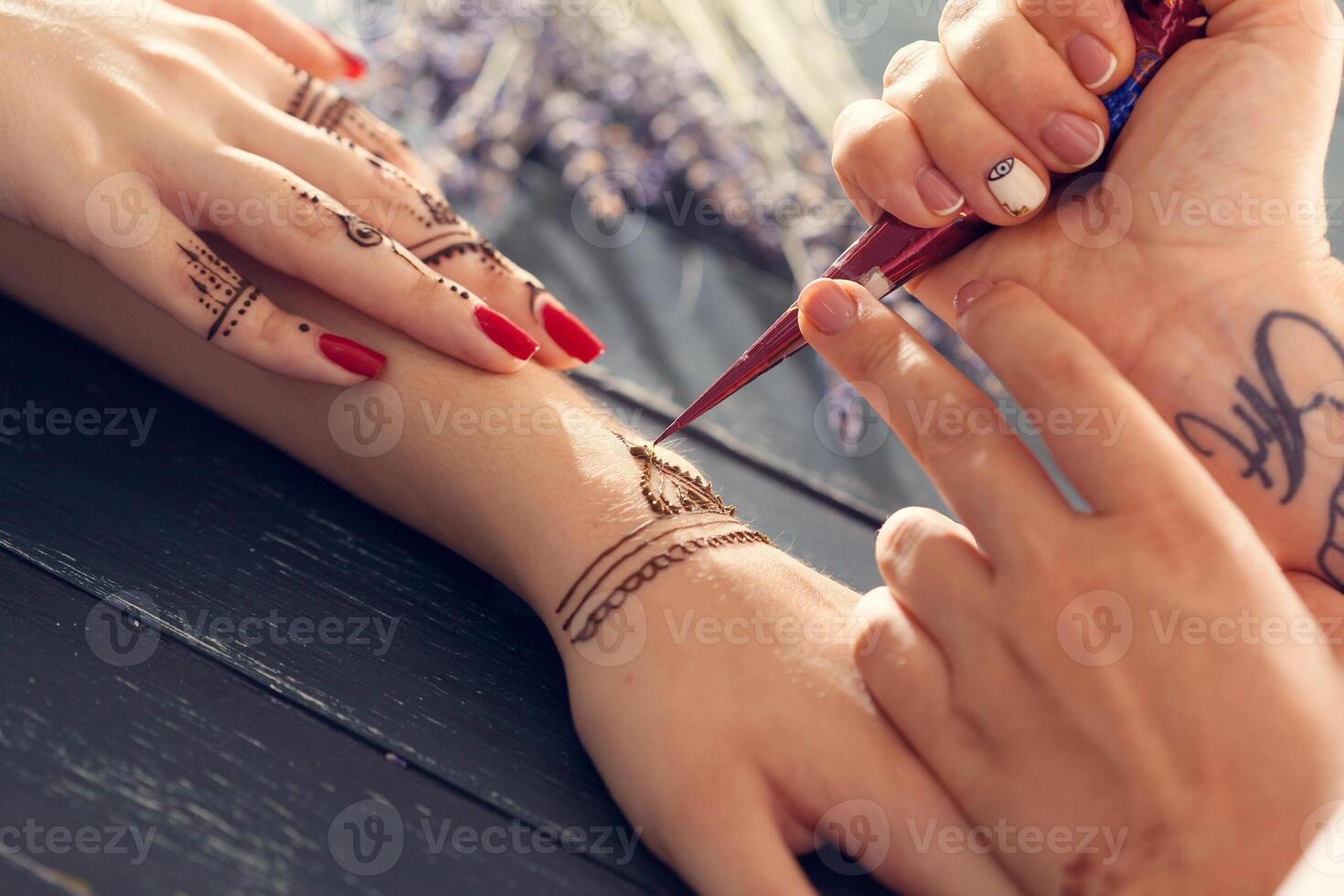 Process of applying mehndi on female hands photo
