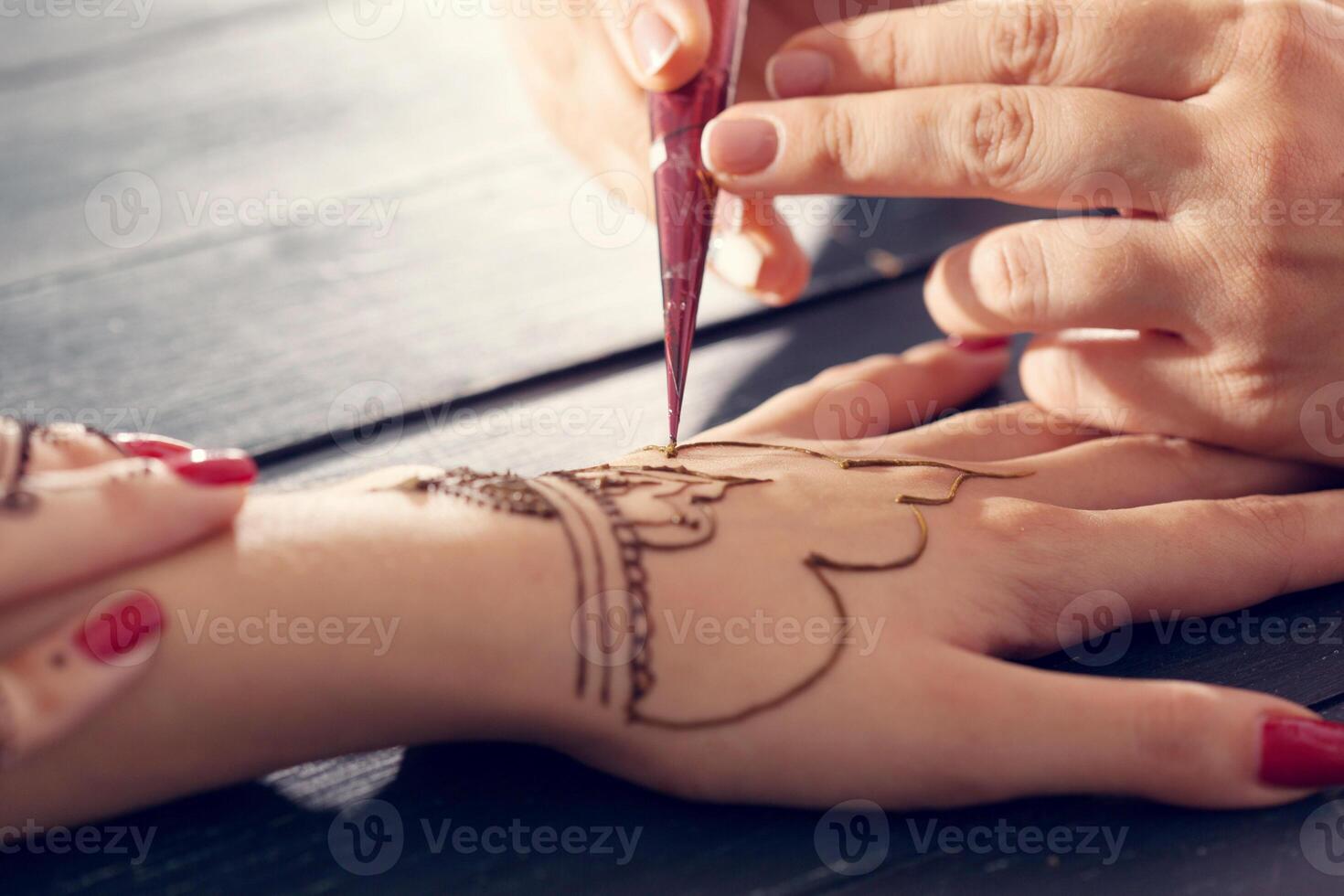 Process of applying mehndi on female hands photo