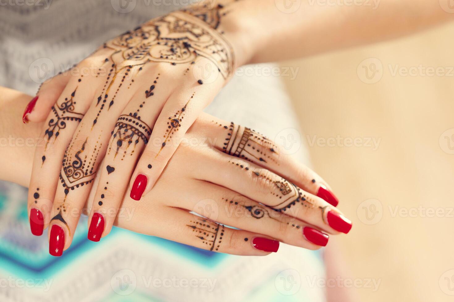 Red manicured hands with Mehndi photo