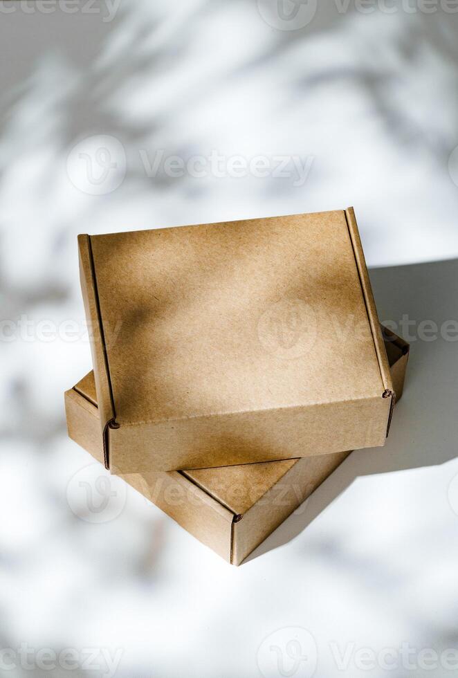Freshly packed cardboard boxes resting on a white surface, illuminated by soft natural light photo