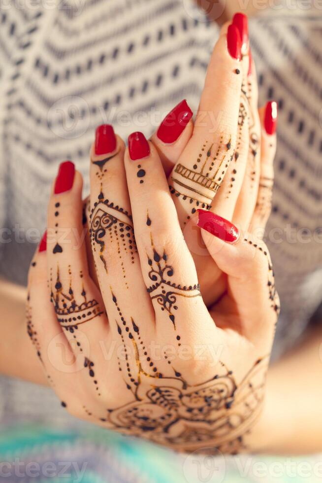 Red manicured hands with Mehndi photo