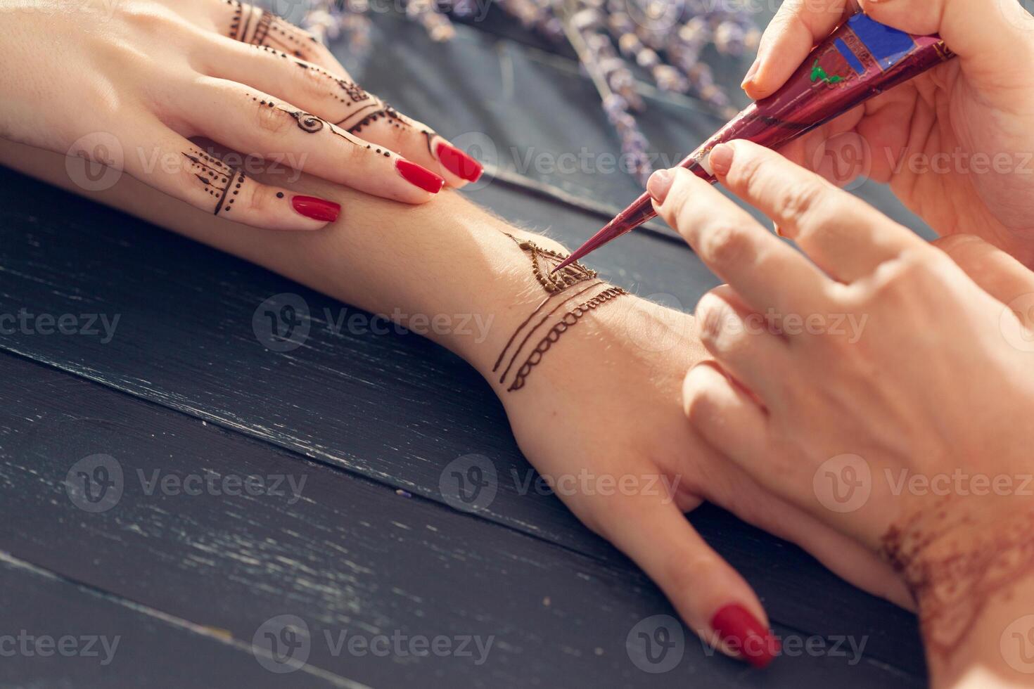 Process of applying mehndi on female hands photo