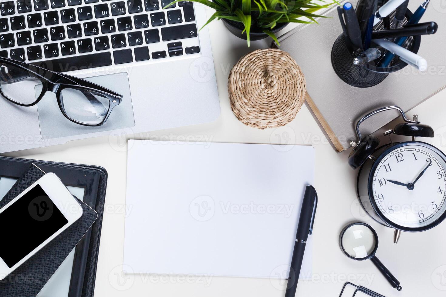 White office desk table with a lot of things on it. Top view photo