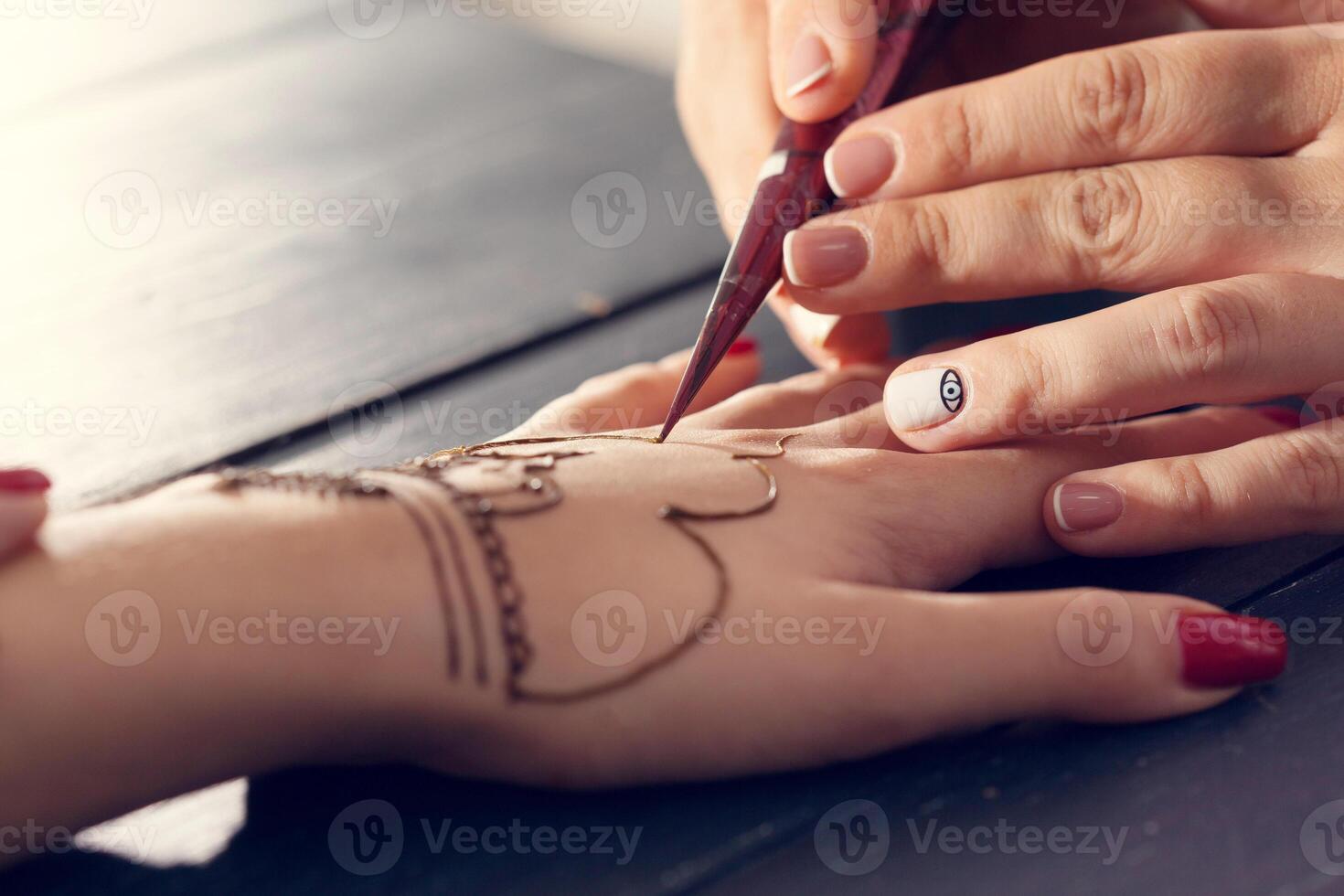 Process of applying mehndi on female hands photo
