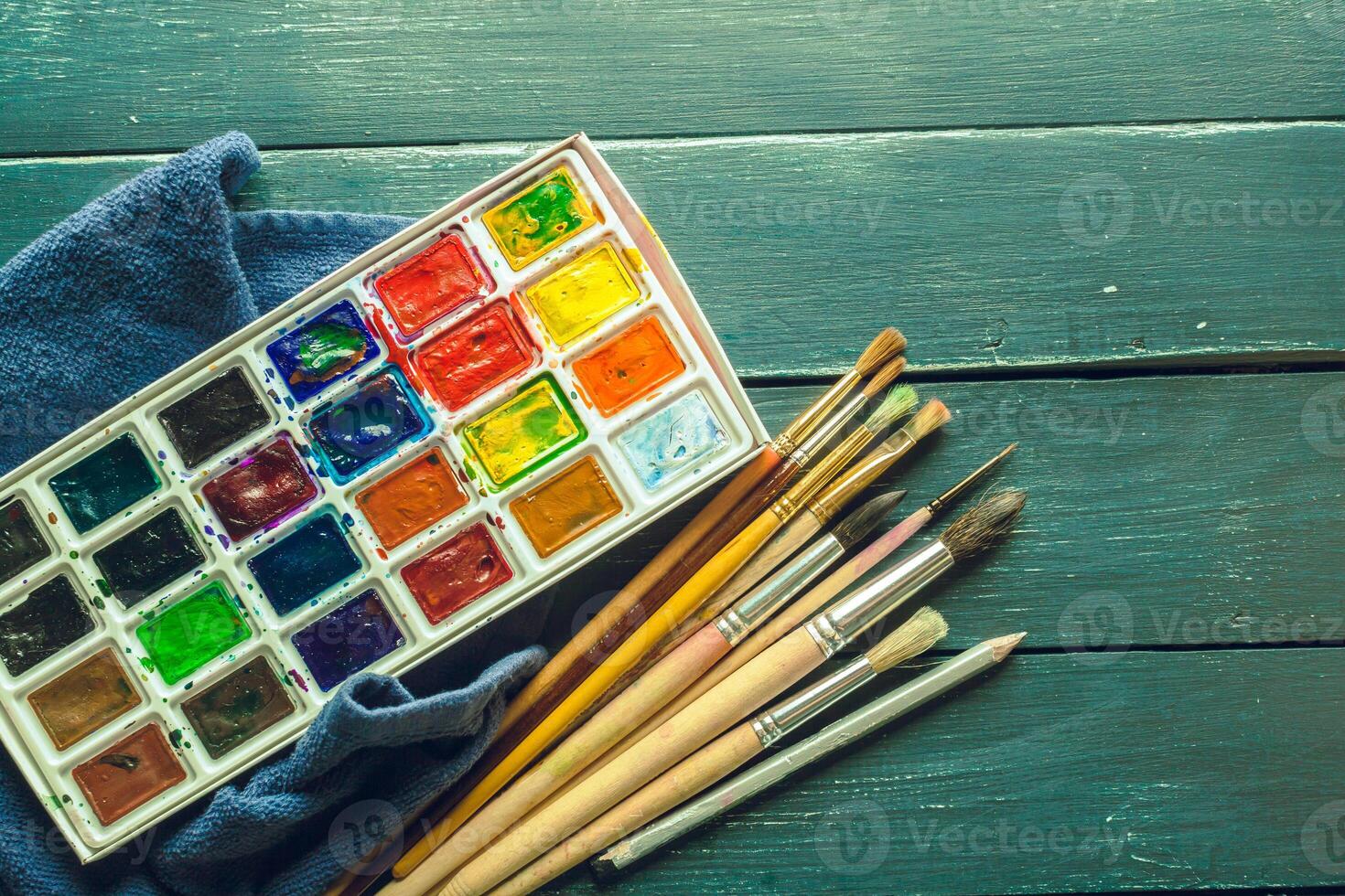 Set of watercolor paints and paintbrushes for painting photo