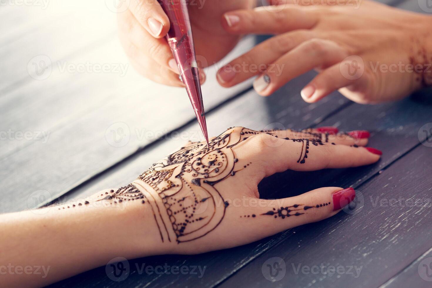 Process of applying mehndi on female hands photo