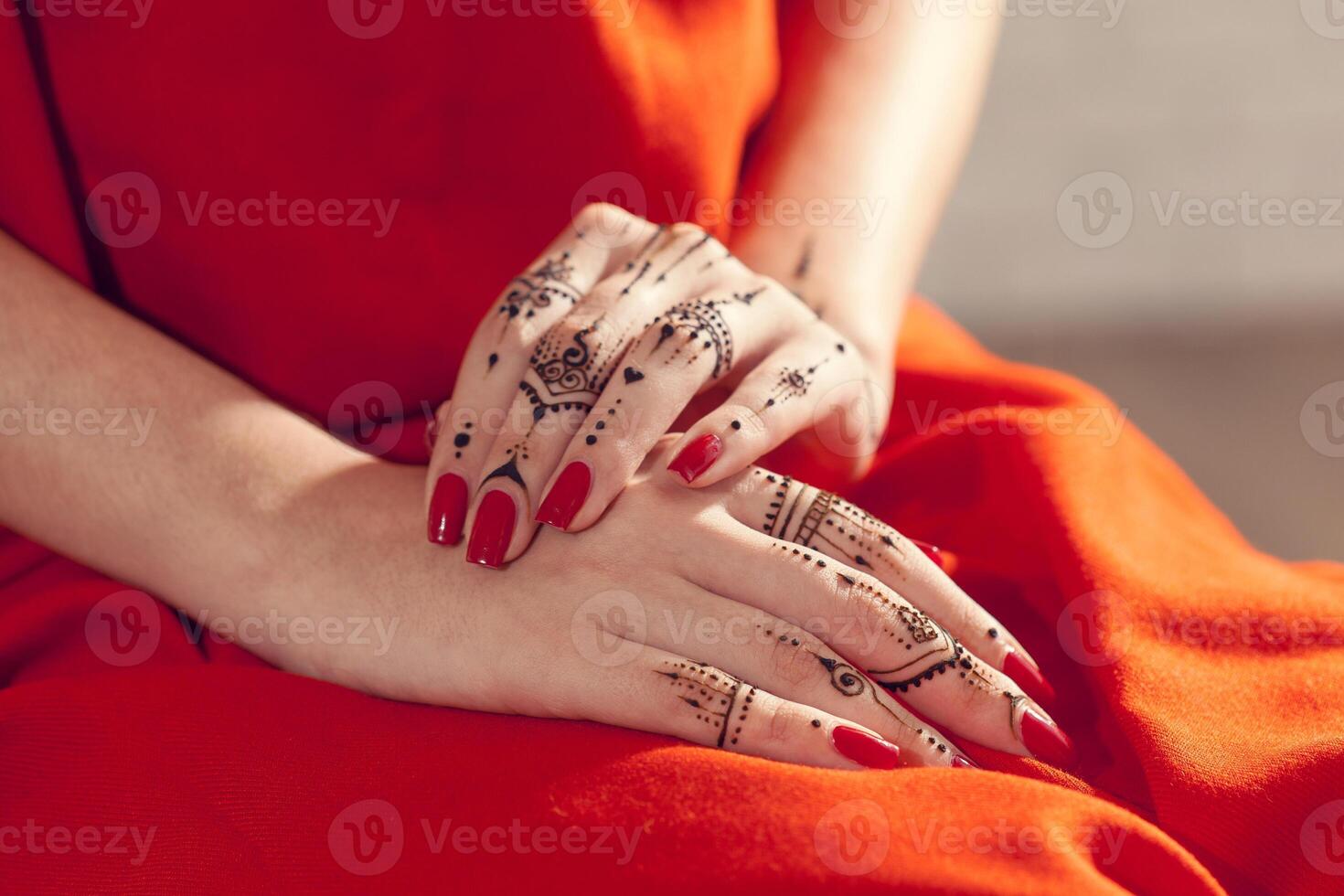 Red manicured hands with Mehndi photo
