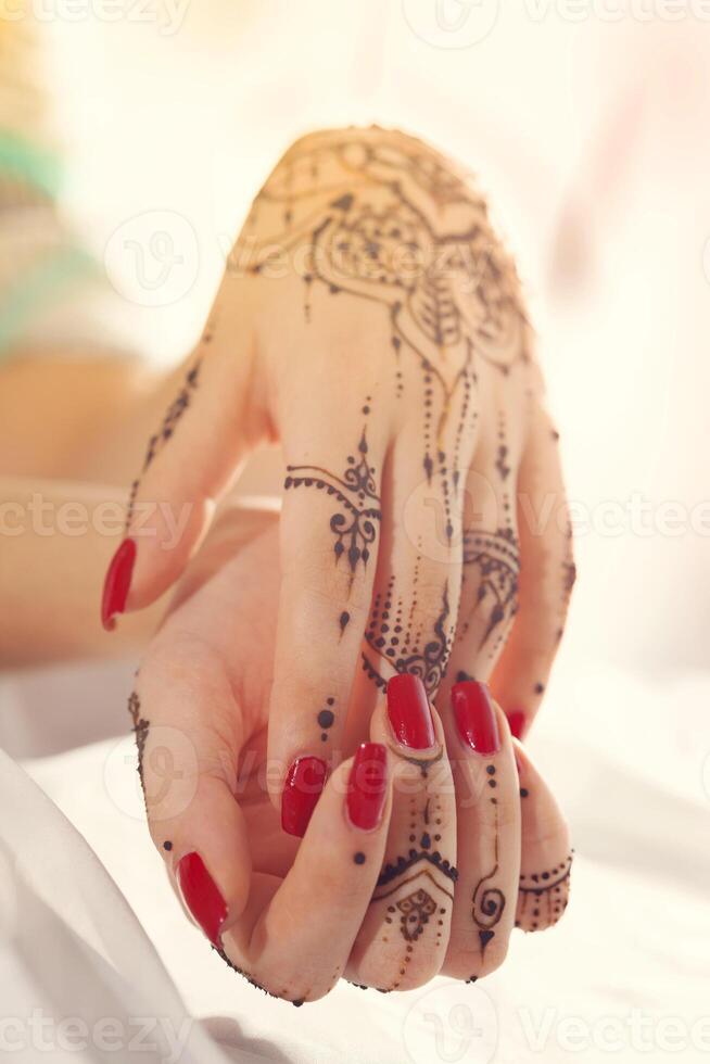 Red manicured hands with Mehndi photo