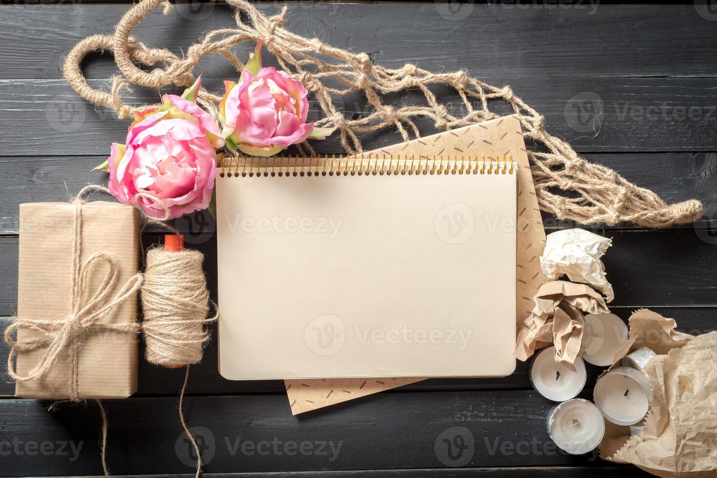 flowers and a notebook on wooden background photo