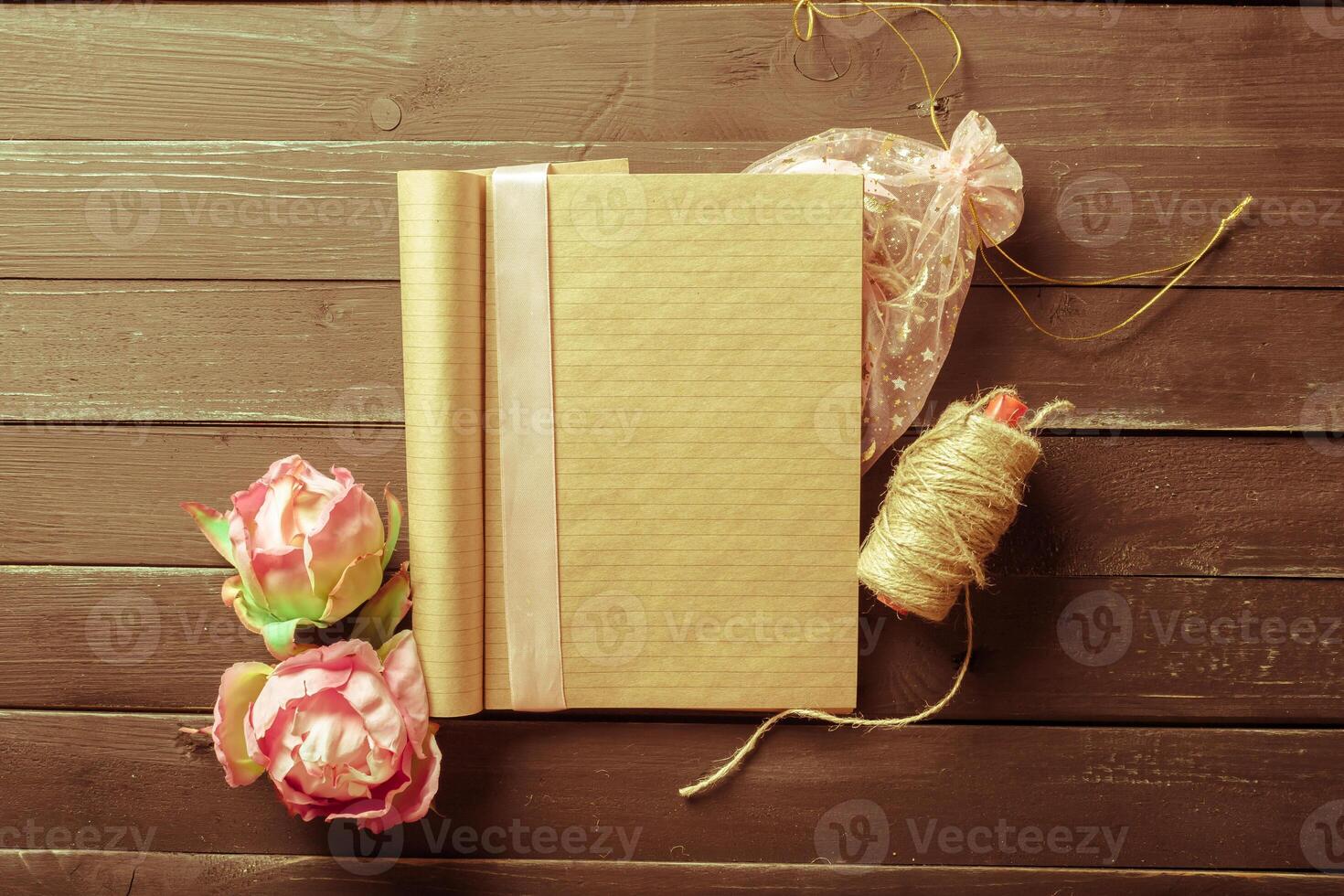 flowers and a notebook on wooden background photo