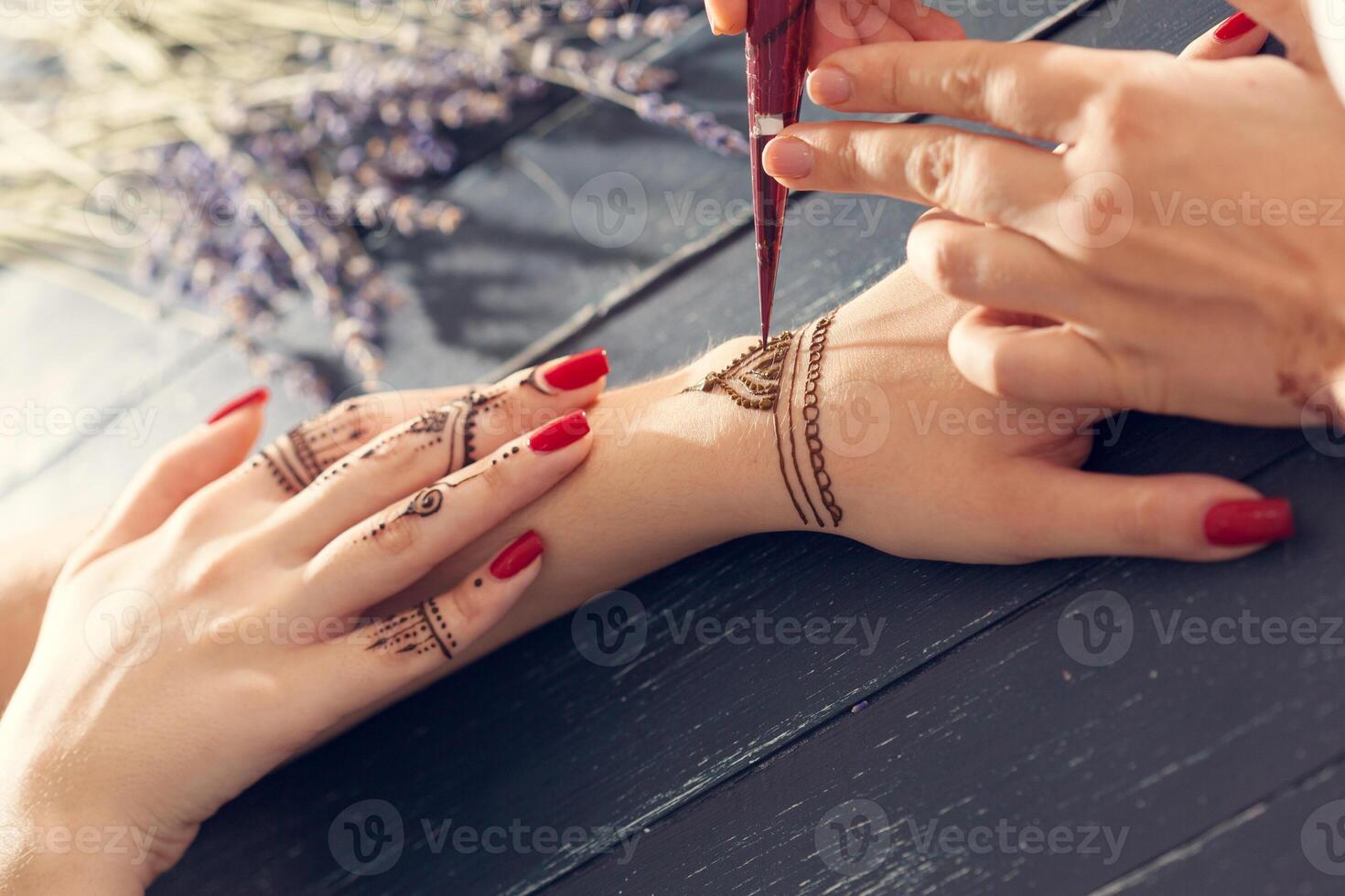 Process of applying mehndi on female hands photo