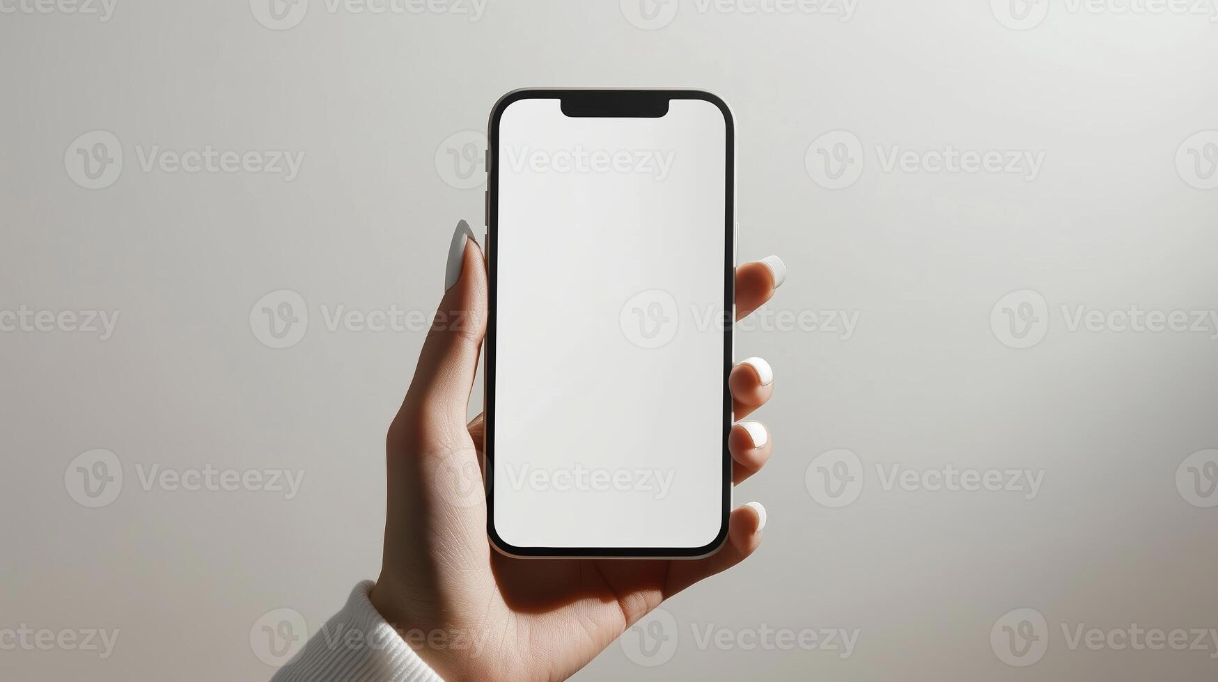 A person holding a blank smartphone in front of a minimalist background during daylight photo