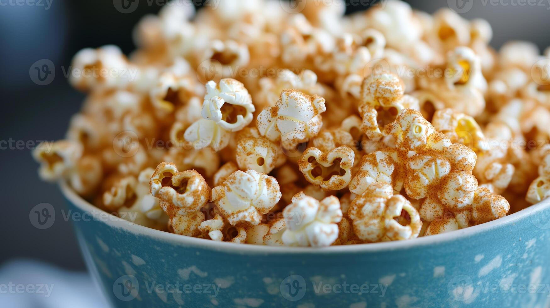 Delicious caramel popcorn in a blue bowl, perfect for movie nights or snack time at home photo