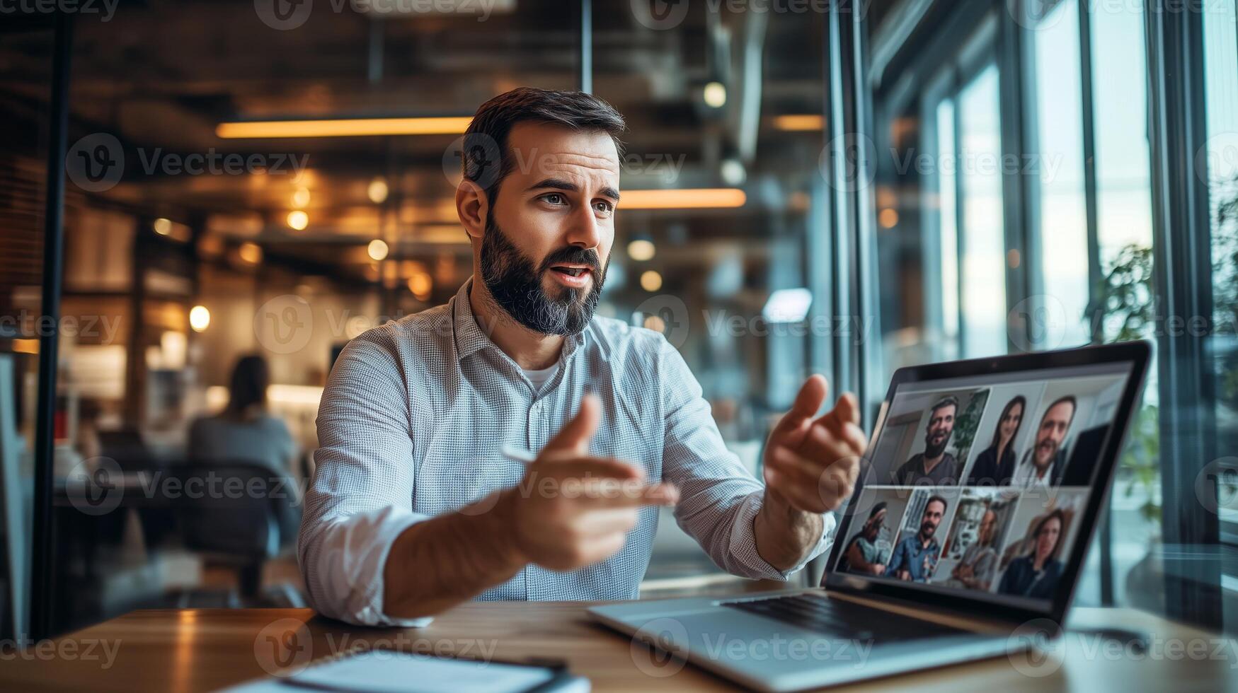 A professional man engages in a conference with colleagues at a modern office during the day while seated at a wooden table photo