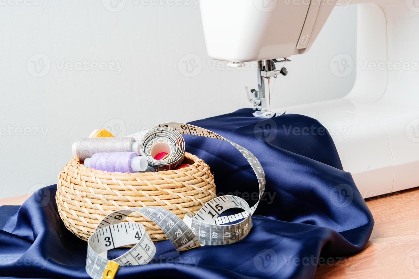 Sewing tools and materials arranged on fabric with a sewing machine in a bright workspace photo