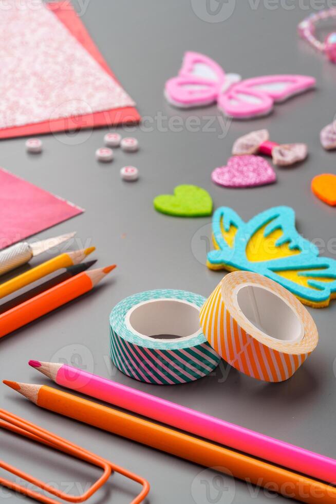 Crafting materials and tools arranged on a gray surface during a creative project photo