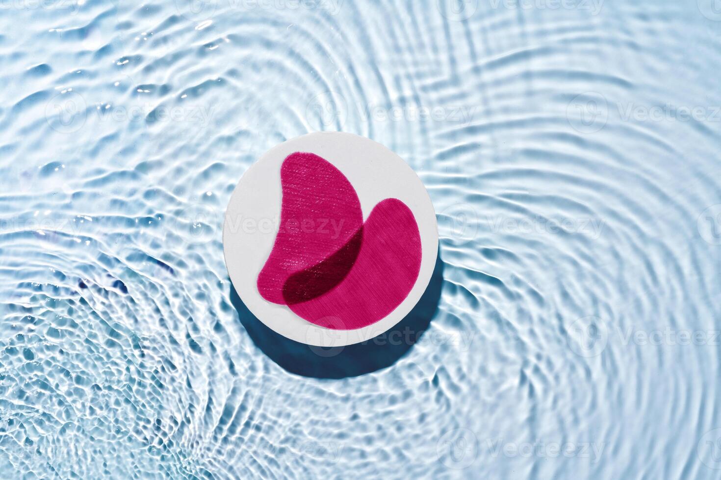 Eye patches floating on clear water with gentle ripples photo