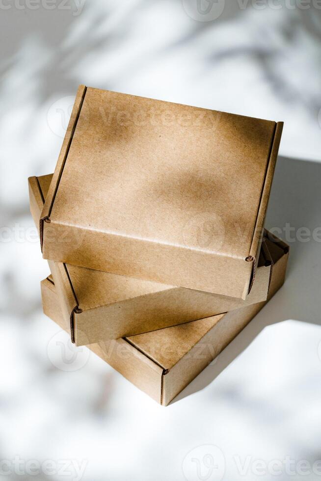 Freshly packed cardboard boxes resting on a white surface, illuminated by soft natural light photo