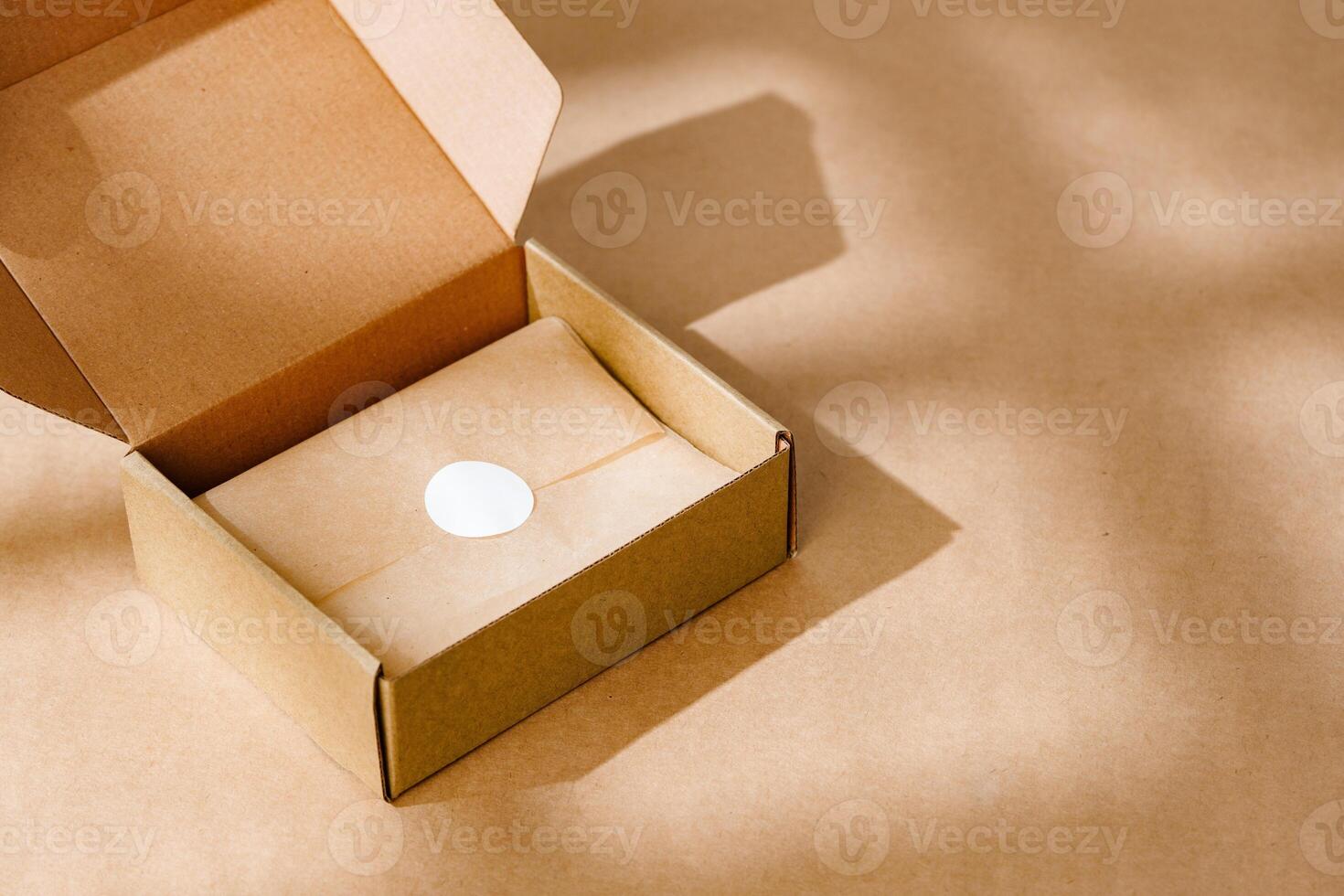 A sealed kraft box containing a wrapped item, positioned on a textured brown surface for an unboxing experience photo