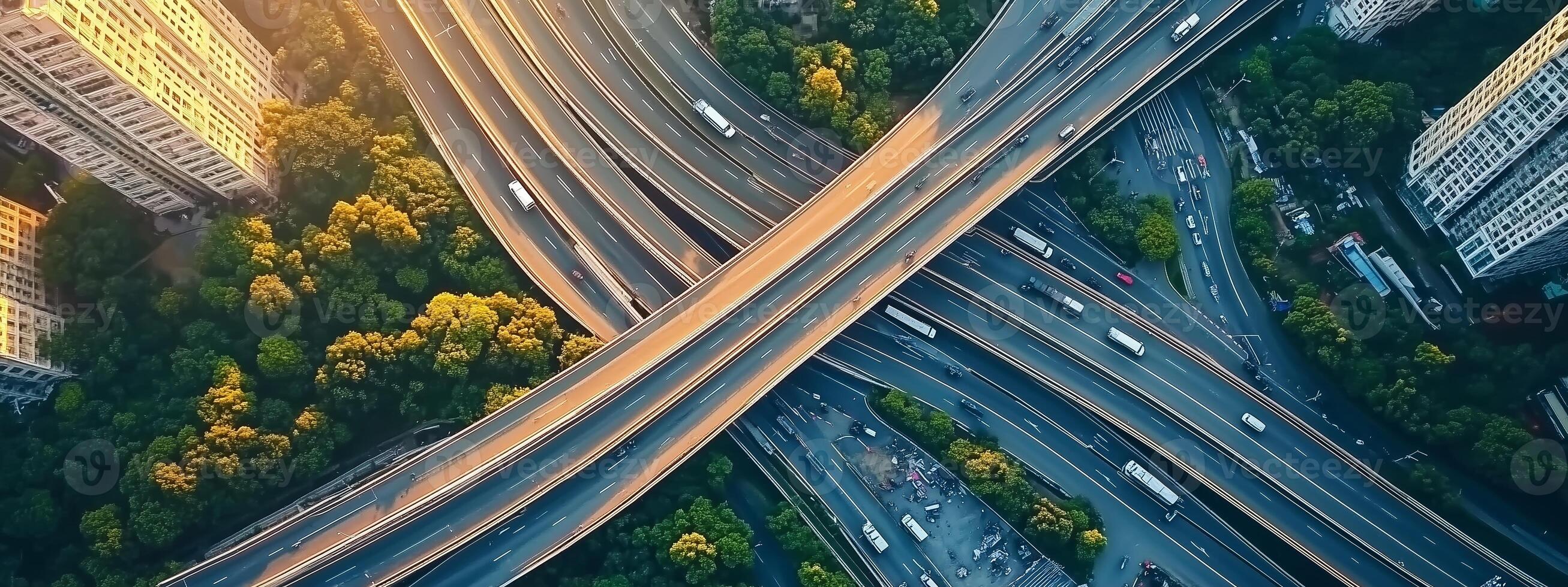 Aerial view of urban highway interchange surrounded by greenery at sunset in a bustling city photo