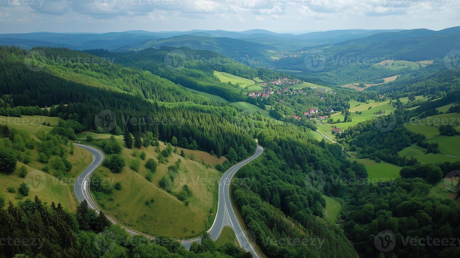 Scenic view of winding road through lush green hills in a mountainous area on a sunny day photo