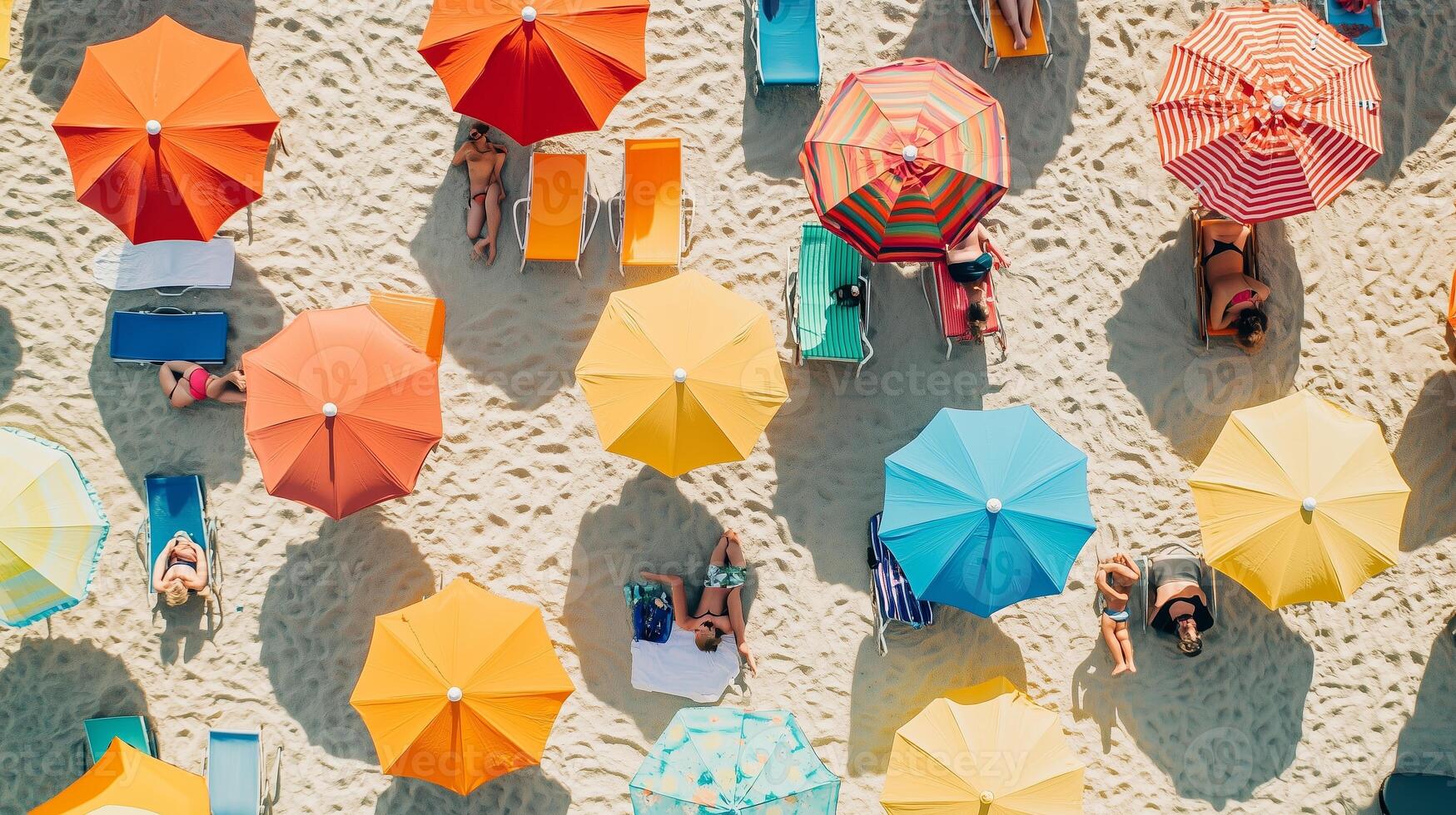 Colorful beach umbrellas shade sunbathers on a sandy shore in a vibrant coastal setting during a sunny summer day photo