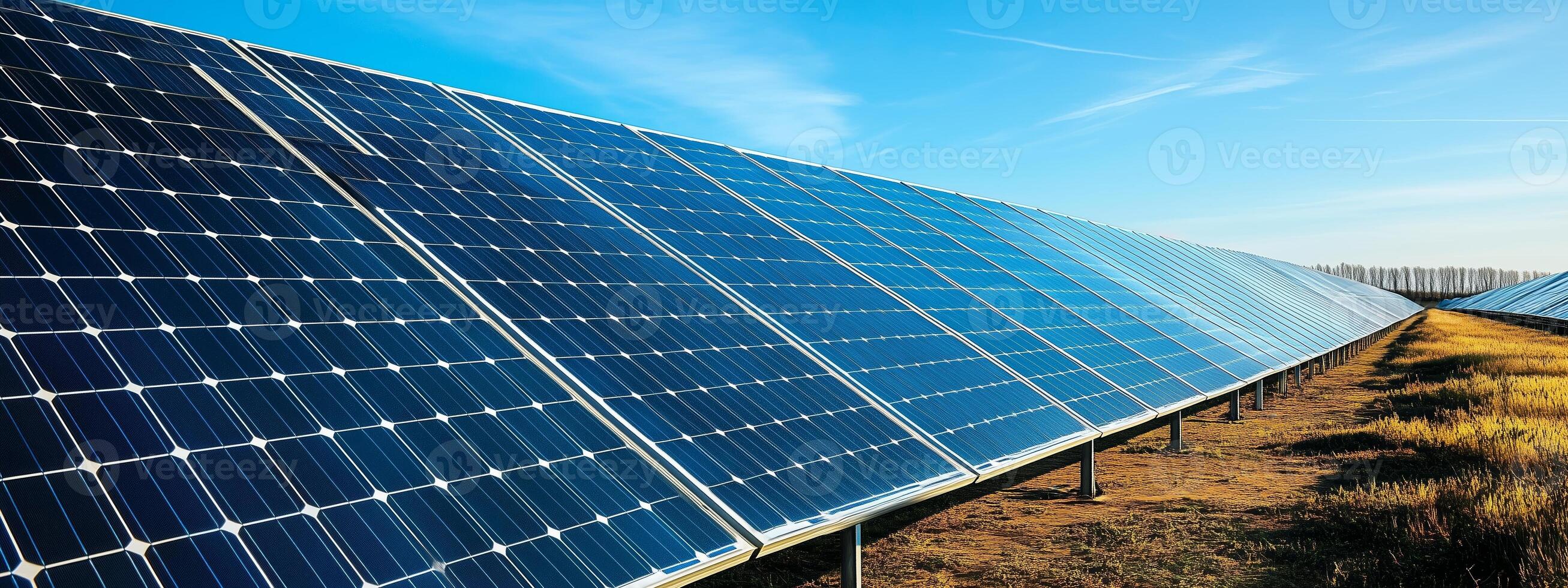A vast array of solar panels harnessing renewable energy under a clear blue sky at a solar farm during daylight hours photo
