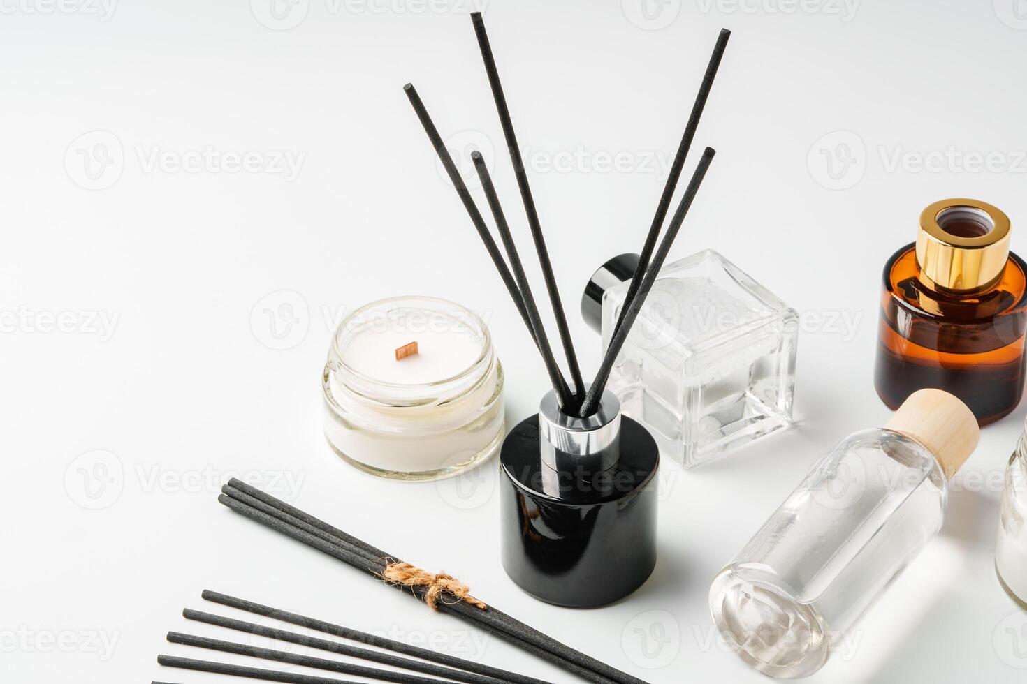 Aromatic essentials including scented candles, incense sticks, and diffusers arranged on a light background photo