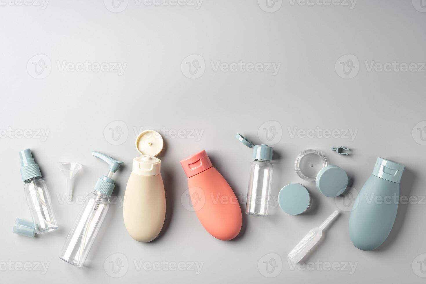 Collection of various reusable cosmetic containers arranged on a light gray background photo