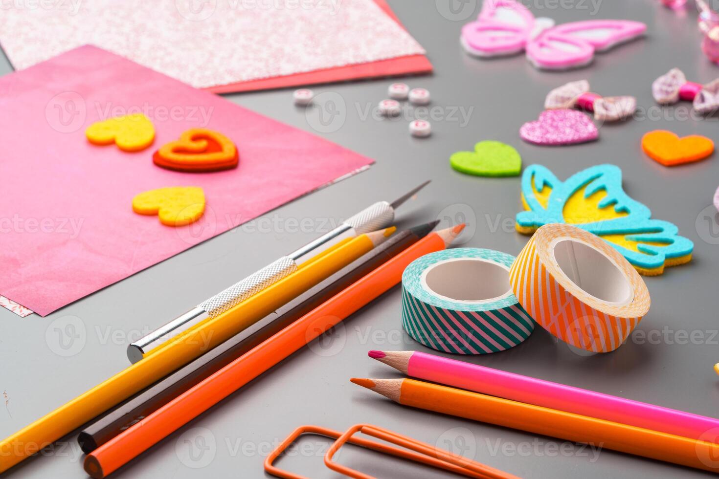 Crafting materials and tools arranged on a gray surface during a creative project photo