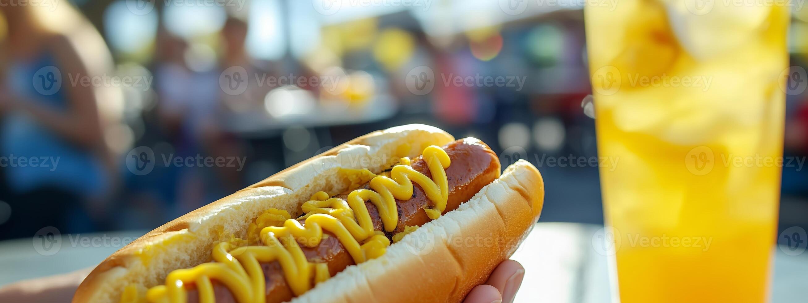 Enjoying a delicious hot dog with mustard at a vibrant outdoor food festival on a sunny day photo