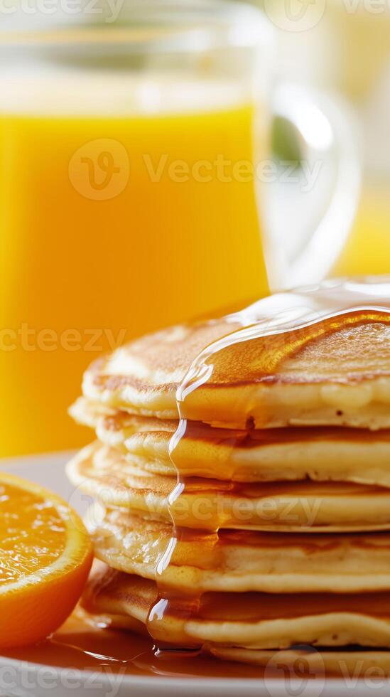 Delicious stack of fluffy pancakes drizzled with syrup served with fresh orange slices and a glass of juice in a bright morning setting photo