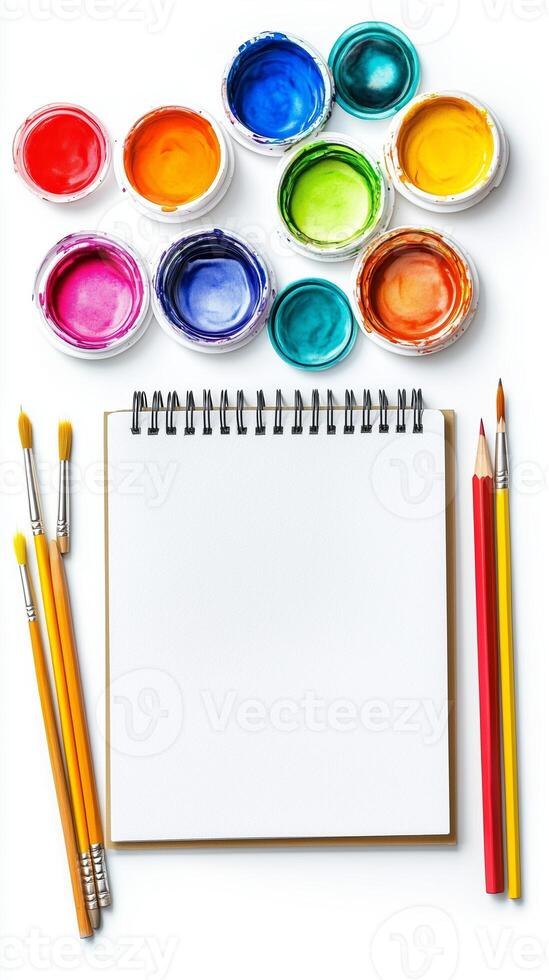 Art supplies arranged with paint, brushes, and a blank sketchbook ready for creative expression in a bright and colorful workspace photo