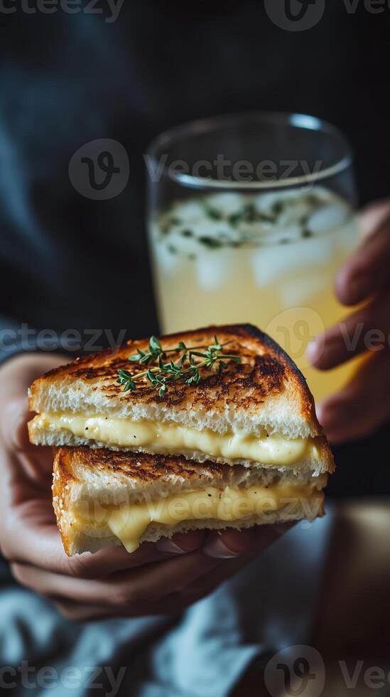 Cheesy grilled sandwich served alongside a refreshing beverage in a cozy indoor setting during the evening photo
