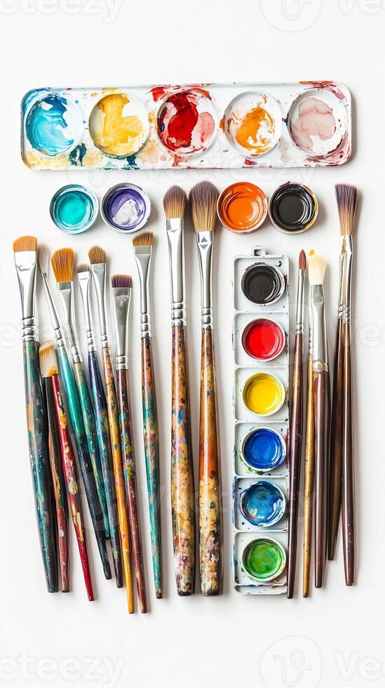 A vibrant collection of paintbrushes and watercolors arranged neatly on a white surface, showcasing artistic tools for creative expression photo