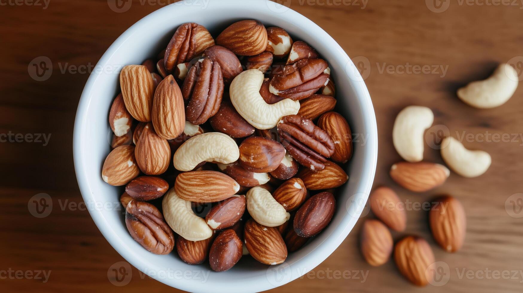 A variety of mixed nuts including almonds, pecans, cashews, and Brazil nuts in a bowl on a wooden table photo
